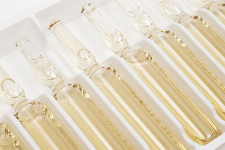 Closeup of row of yellow ampules in package with selective focus
