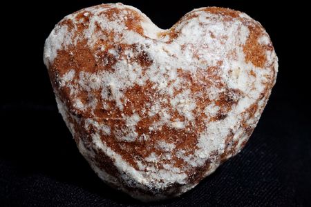 Brown gingerbread in shape of heart isolated on black の写真素材