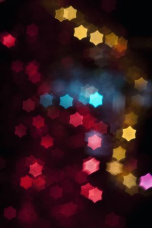 Out of focus and blurred colored star shape lights on black background