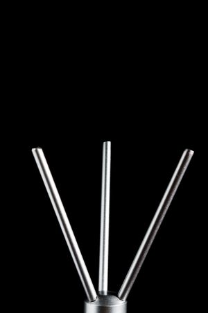 Abstract metal three-arms base isolated on black with selective focusの写真素材