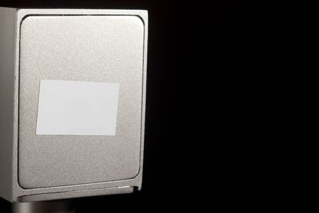 Abstract metal plate with blank paper sticker against black with copy spaceの写真素材