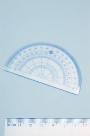 Closeup of blue measuring ruler with blurred protractor in the backgroundの写真素材