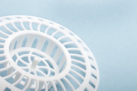 Part of white kitchen sink grid stopper on blue with selective focusの写真素材