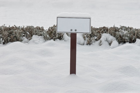 Closeup of blank sign board in snow with selective focusの写真素材