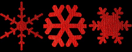 Set of red snowflakes with woven textile texture isolated on black backgroundの写真素材