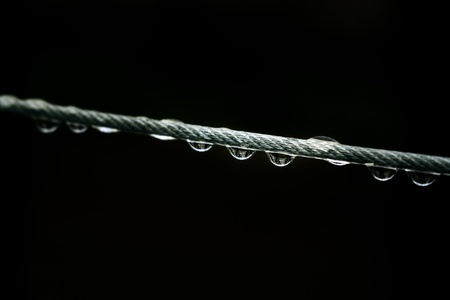 Water drops on thread against dark background with shallow depth of fieldの写真素材