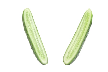 Falling two cut halves of green cucumber isolated on whiteの写真素材