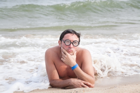 Geek in glasses posing on the beach with duckface and selective focusの写真素材