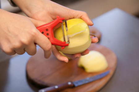 Closeup of hand peeling apple with peelerの写真素材