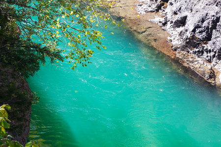 Sunlit emerald whitewater of mountain riverの写真素材
