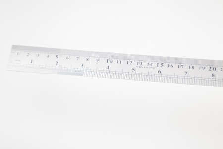 stainless steel ruler with inches and centimeters on whiteの写真素材