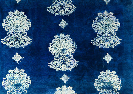 Stylized dark royal ornament stamped on paper against blue background