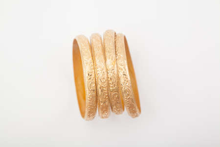 Top view of encrusted massive golden bracelets on white backgroundの写真素材