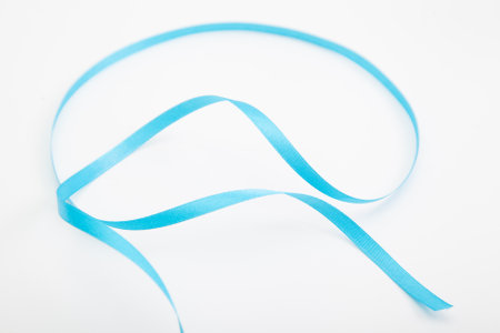 Curved blue wavy ribbon on white with selective focus