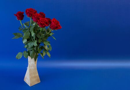 postcard template, copy space with vase with flowers roses on a blue backgroundの写真素材
