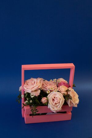 postcard template, copy Space - a basket of flowers with pink roses on a blue backgroundの写真素材