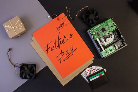 Holiday greeting card for Father's Day on a black background - machines, computer boards, with the...