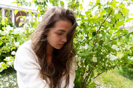 young beautiful girl in the garden with jasmine, summer