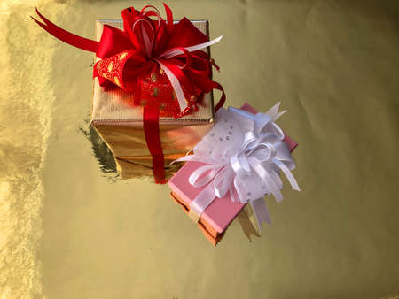 photo close-up Christmas boxes with presents on a gold backgroundの写真素材