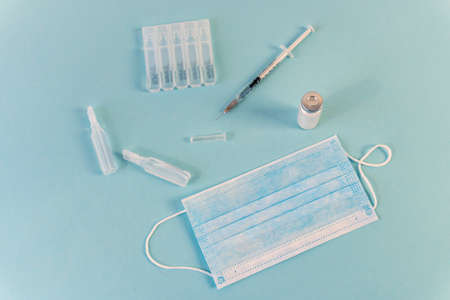 Flat Lay for medical theme and vaccinations from COVID-19. Medicine, vaccine, syringe, mask.