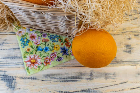 Still life with oranges and basket on old bright wooden backgroundの写真素材