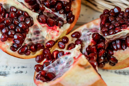 Pomegranates in a basket and on the table on a wooden background.の写真素材