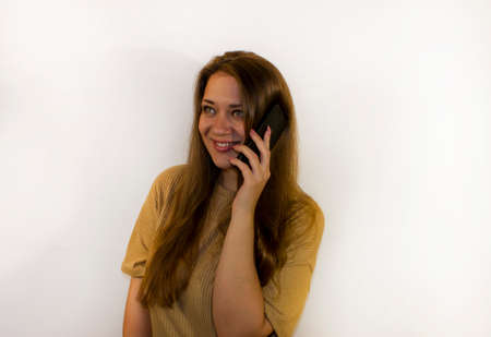 young beautiful woman with a smartphone, writes a message, makes a selfie, communicatesの写真素材