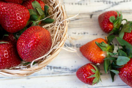Strawberry in basket and on table on wooden backgroundの写真素材