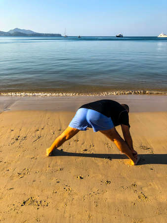 a man goes in for sports, does exercises on the seashore