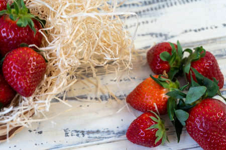 Strawberry in basket and on table on wooden backgroundの写真素材