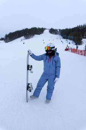 photo of young woman with snowboard at ski resortの写真素材