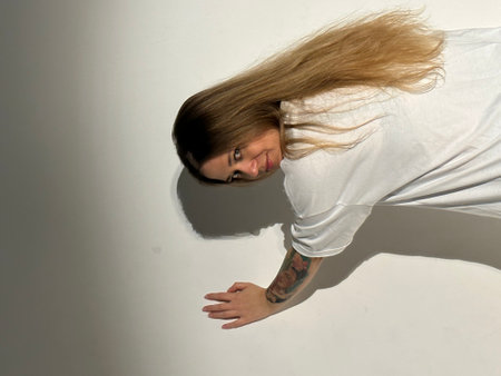 Young beautiful woman with long hair, green eyes in a white t-shirt