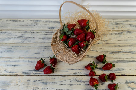 Strawberry in basket and on table on wooden backgroundの写真素材