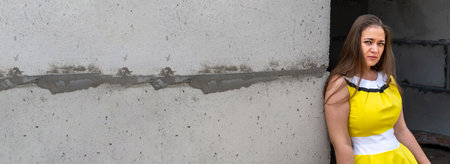 Young beautiful girl in a yellow dress on a smart building construction backgroundの写真素材