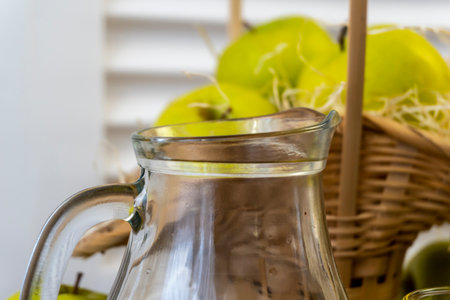 Green apples, basket with apples and jug with apple juice on wooden backgroundの写真素材