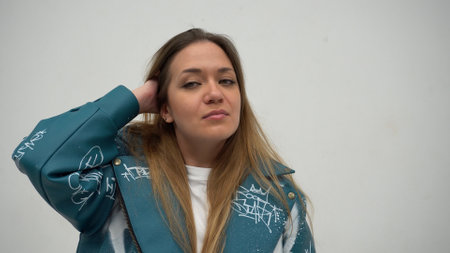 Young beautiful woman with long hair and green eyes. dressed in a stylish leather jacketの写真素材