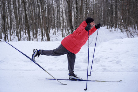 man 50 years old skiing in the forest in winterの写真素材