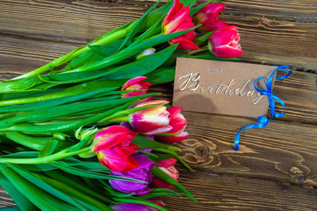 postcard , Internet banner with a birthday greeting, with the inscription - happy birthday, a bouquet of flowers with a note of congratulations, tulipsの写真素材