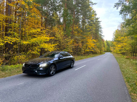 Naberezhnye Chelny, Russia - October 1, 2023: Mercedes-Benz E200 car stands on the road in the autumn forestのeditorial素材