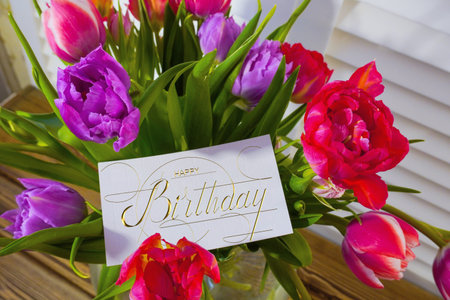 postcard , Internet banner with a birthday greeting, with the inscription - happy birthday, a bouquet of flowers with a note of congratulations, tulipsの写真素材