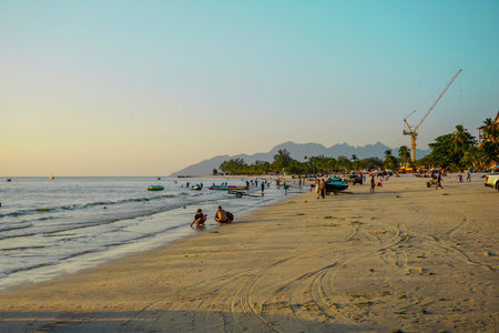 Langkawi, Malaysia - January 29, 2024 : Langkawi island in Malaysia, Chenang beach in the evening, people walk along the beachのeditorial素材