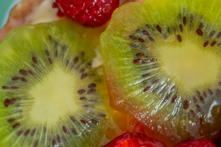 Slice kiwi and a variety of fresh fruits in sweet gelatin. Berries close-up in soft focus. Delicious dessert. Beautiful background of fruit. Food. Top view. Macro.の写真素材