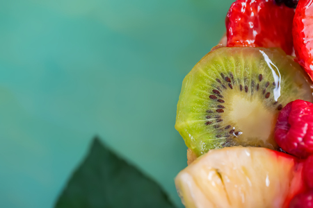 Slice kiwi and a variety of fresh fruits in sweet gelatin. Berries close-up in soft focus. Delicious dessert. Beautiful background of fruit. Food. Top view. Copy space. Macro.の写真素材