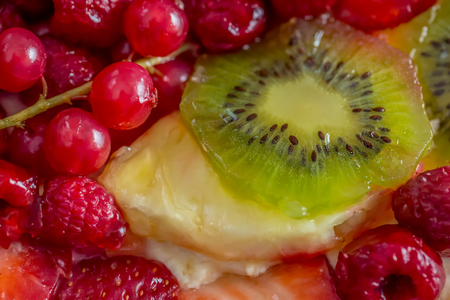 Slice kiwi and a variety of fresh fruits in sweet gelatin. Berries close-up in soft focus. Delicious dessert. Beautiful background of fruit. Food. Top view. Macro.の写真素材