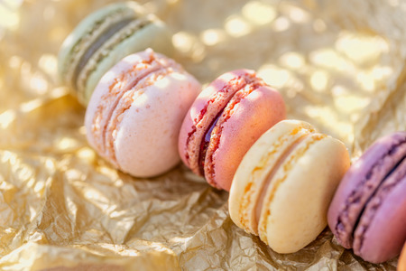 Delicious sweet airy french pastries. Dessert of macarons in the summer evening in the orchard. Natural blurred background. Image in soft focus and close-upの写真素材