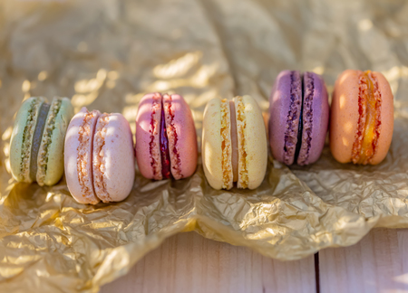 Delicious sweet airy french pastries. Dessert sweets macarons in the summer evening in the orchard. Natural blurred background. Image in soft focus and close-up.の写真素材