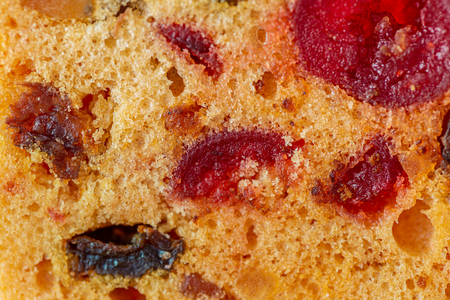 Macro image of a cake slice fruits. Fruitcake with raisin and cherry. Dessert. Close-up of sweet muffins with berry. Soft focus. Blurry background. Copy space.の写真素材