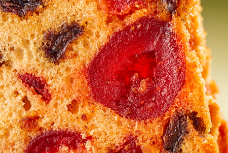 Macro image of a cake slice fruits. Fruitcake with raisin and cherry. Dessert. Close-up of sweet muffins with berry. Soft focus. Blurry background. Copy space.の写真素材