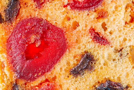 Macro image of a cake slice fruits. Fruitcake with raisin and cherry. Dessert. Close-up of sweet muffins with berry. Soft focus. Blurry background. Copy space.の写真素材