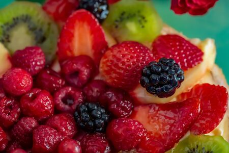 Fruits and berries in sweet gelatin on the cake. Background of strawberries, kiwi, currants, raspberry, pineapple, blackberry. Delicious dessert. Soft focus. Closeup. Top view.の写真素材